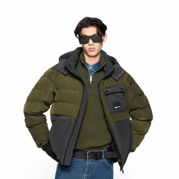 Person wearing a green and black jacket on a white background